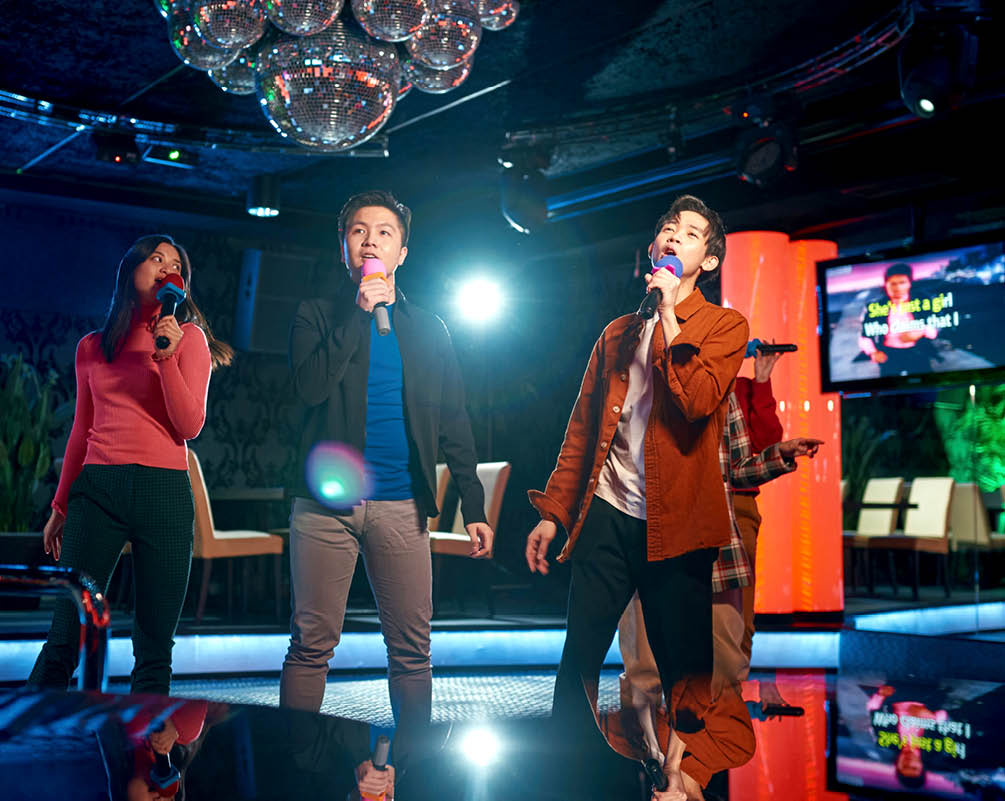 Singing songs karaoke and dancing on night club stage, njoying friendship together in bar, Concept of party, holiday, relaxation, Spend day-off in karaoke together with friends, enjoy time in club